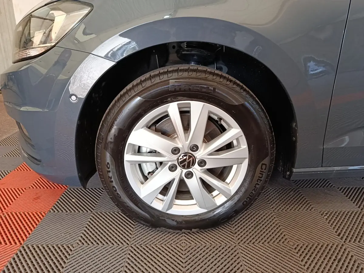 Gros plan sur la roue avant gauche grise claire du Volkswagen Touran 2024 avec jante alliage et pneu Pirelli.