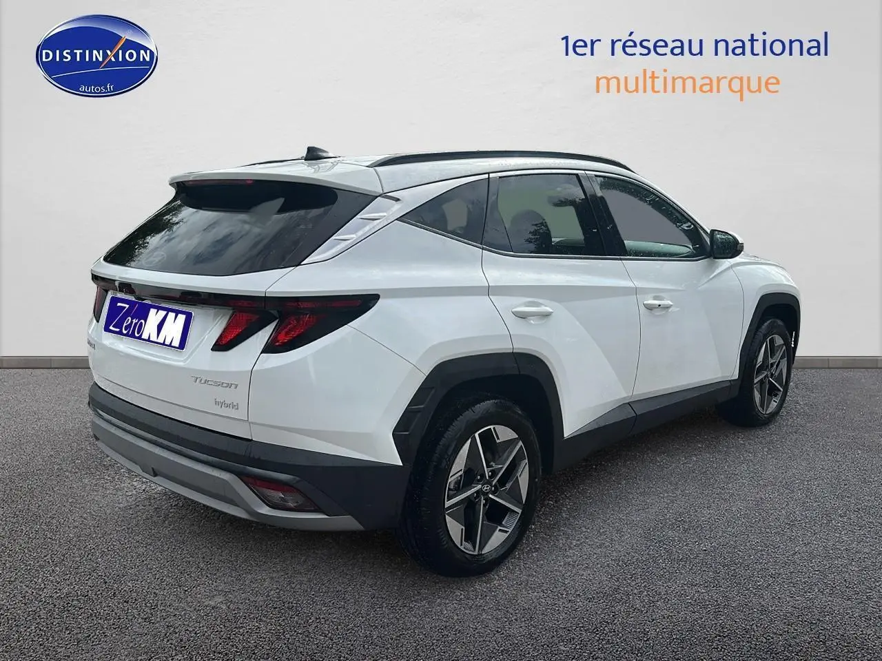 Vue 3/4 arrière droite du Hyundai Tucson blanc sérénité avec jantes alliage 18 pouces et vitres teintées.