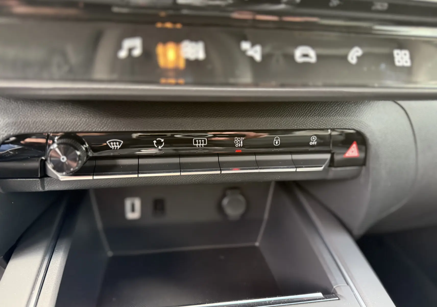 Gros plan sur la console centrale noire du Citroën C5 Aircross 2025, avec boutons de commande et rangement visible.