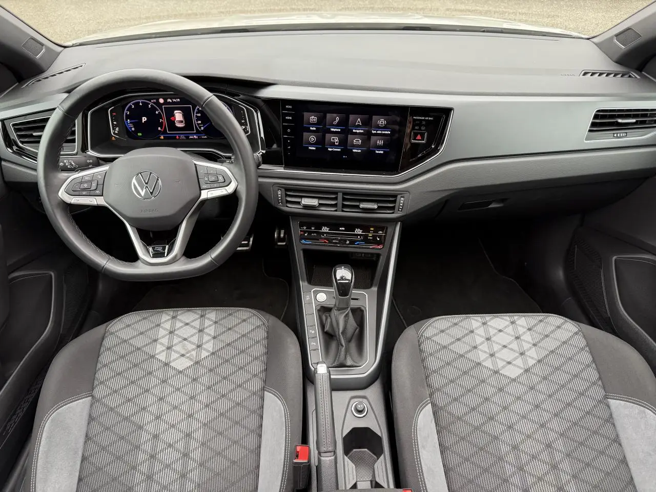 Intérieur Volkswagen Taigo 2024, vue du poste de conduite avec volant multifonction et écran tactile central.