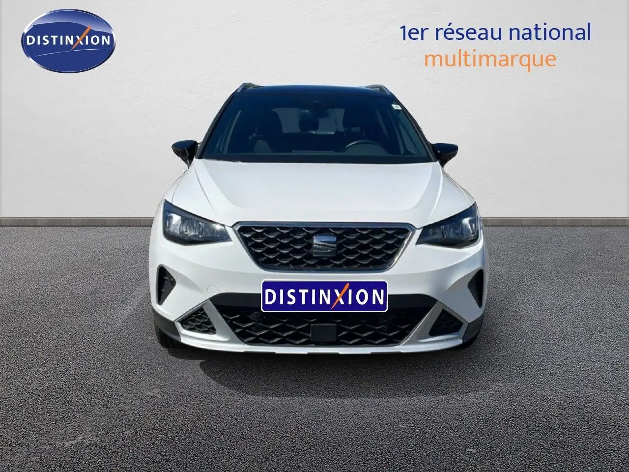 Vue frontale d’un SEAT Arona blanc avec toit noir, mettant en valeur sa calandre et ses phares LED distinctifs.