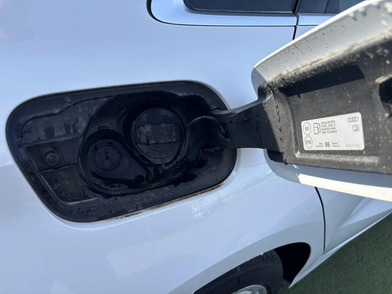 Gros plan sur la trappe à carburant côté gauche d'une Audi A3 Sportback 2024 en blanc Arkona.