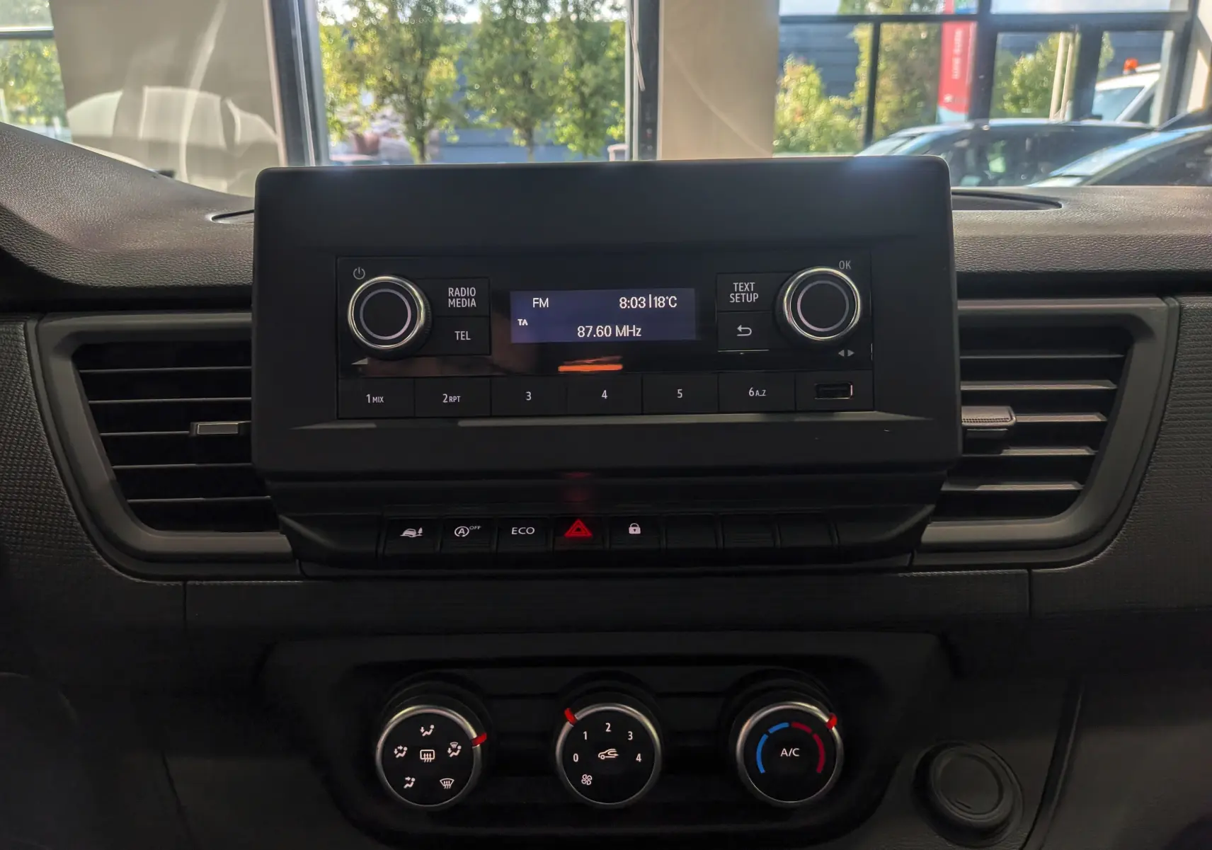 Tableau de bord du Renault Trafic Cabine Approfondie 2023, vue frontale centrée sur la console multimédia et climatisation.