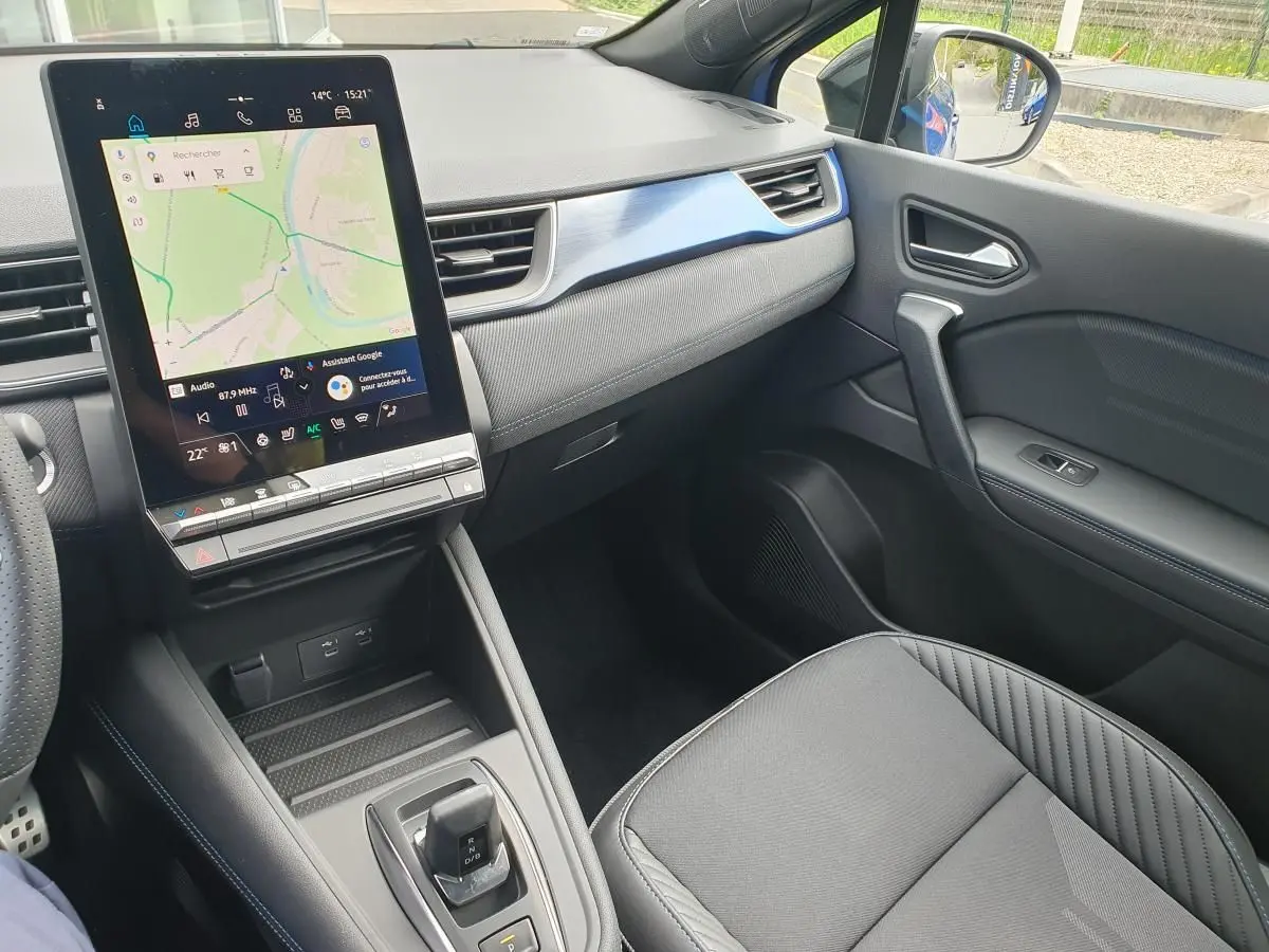 Vue intérieure côté passager du Renault Captur 2026, avec écran tactile vertical et sellerie noire élégante.