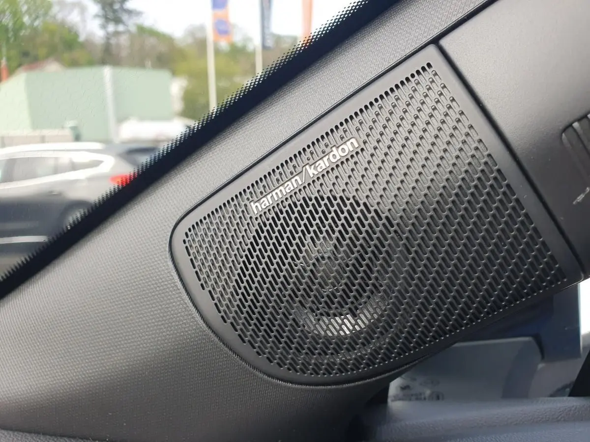 Gros plan sur l’enceinte Harman Kardon noire intégrée dans l’habitacle du Renault Captur bleu Iron.