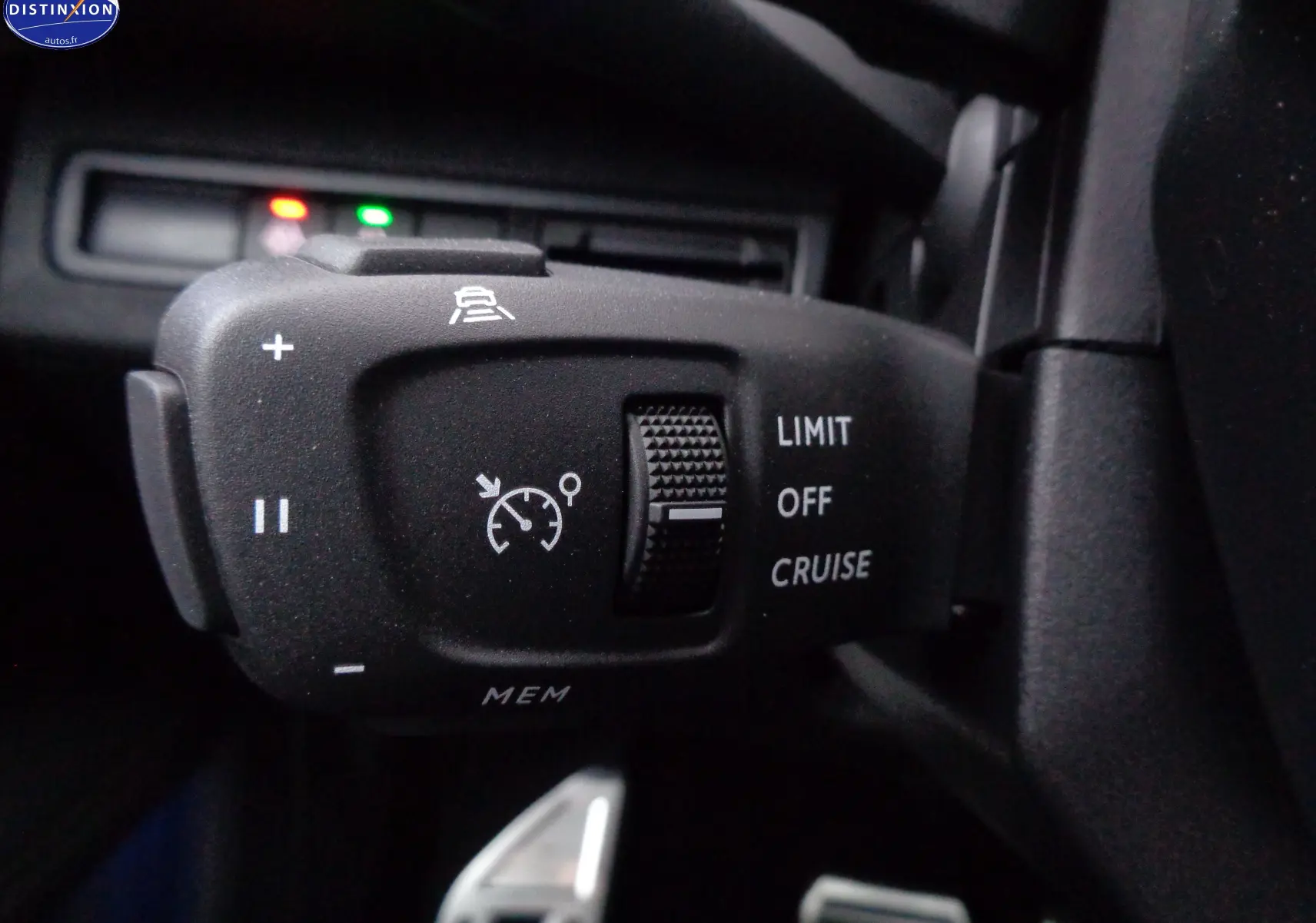 Gros plan sur la commande de régulateur de vitesse du Peugeot 3008 gris Artense 2023, avec molette et symboles blancs.