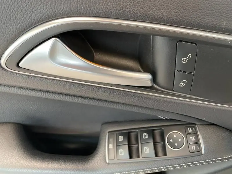 Poignée de porte intérieure côté gauche d'une Mercedes GLA 200 Sensation 2017 avec commandes de verrouillage et lève-vitres.