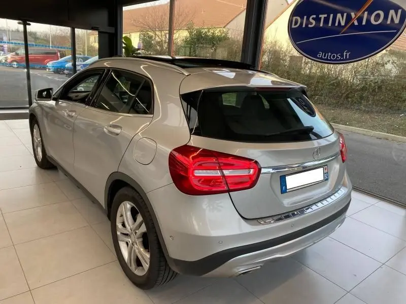 Vue 3/4 arrière droite d'un Mercedes GLA 200 Sensation gris montagne, avec feux arrière LED et toit ouvrant visible.