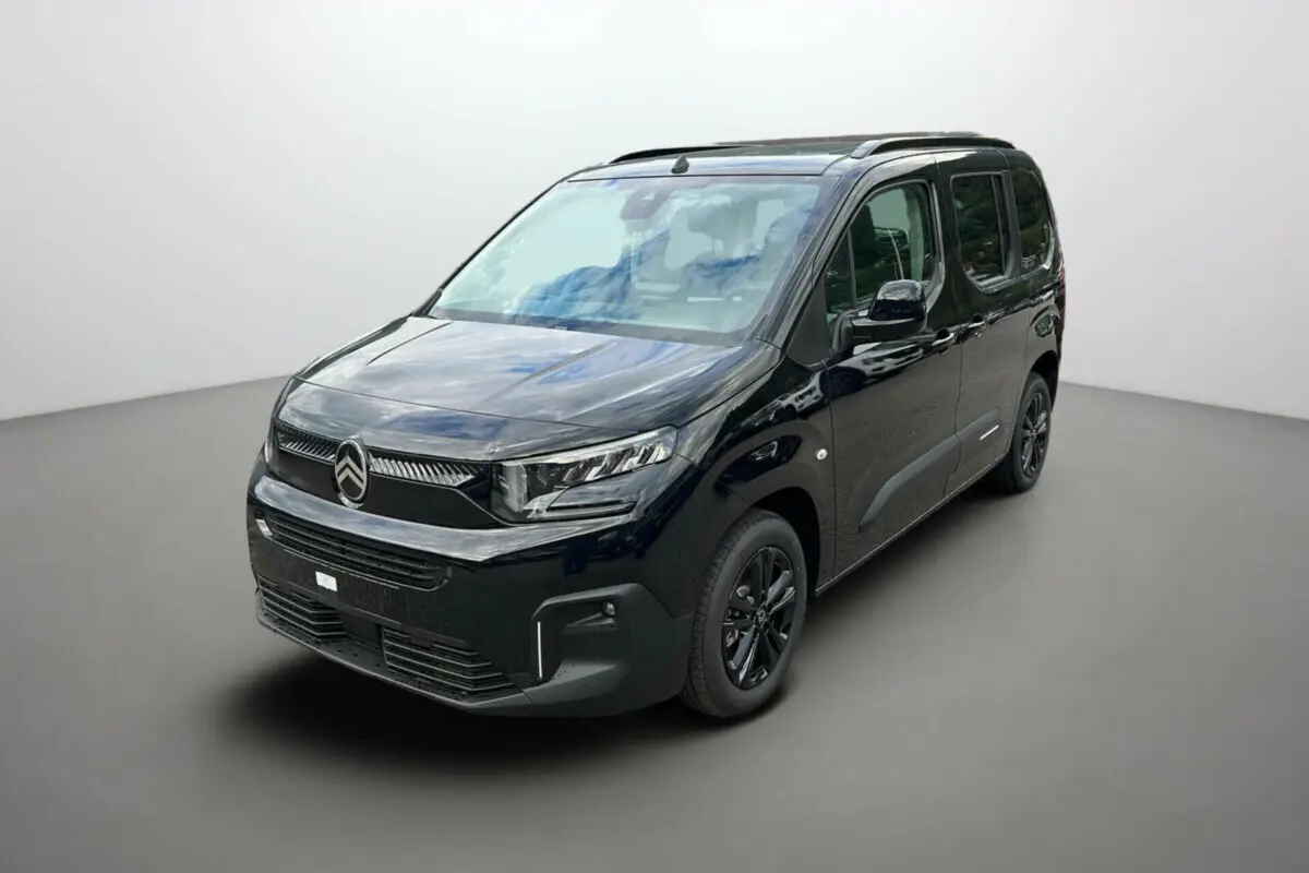 Vue 3/4 avant droit du Citroën Berlingo noir Perla Nera avec barres de toit et jantes alu noires.