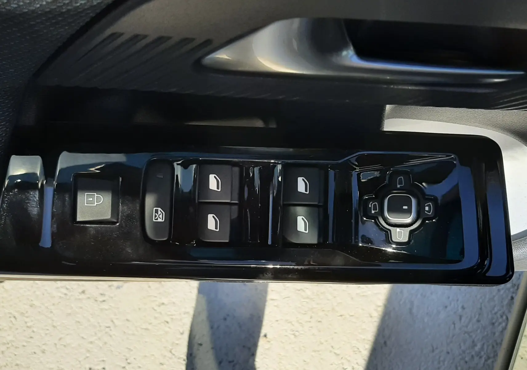 Gros plan sur la commande des vitres électriques côté gauche d’un Citroën C5 Aircross 2026 vert Astoria avec toit noir.
