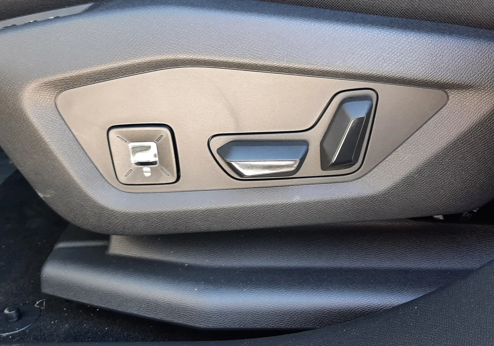 Gros plan sur les commandes électriques de réglage du siège côté conducteur du Citroën C5 Aircross hybride 2026.