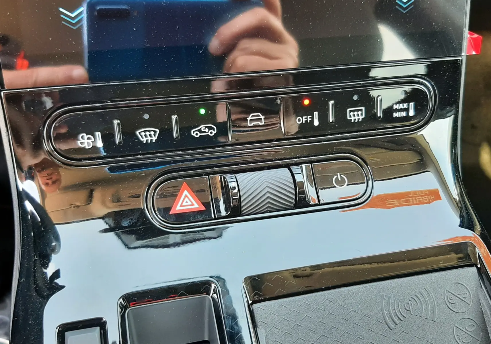 Gros plan sur la console centrale noire brillante du Citroën C5 Aircross hybride avec commandes clim et frein électrique.