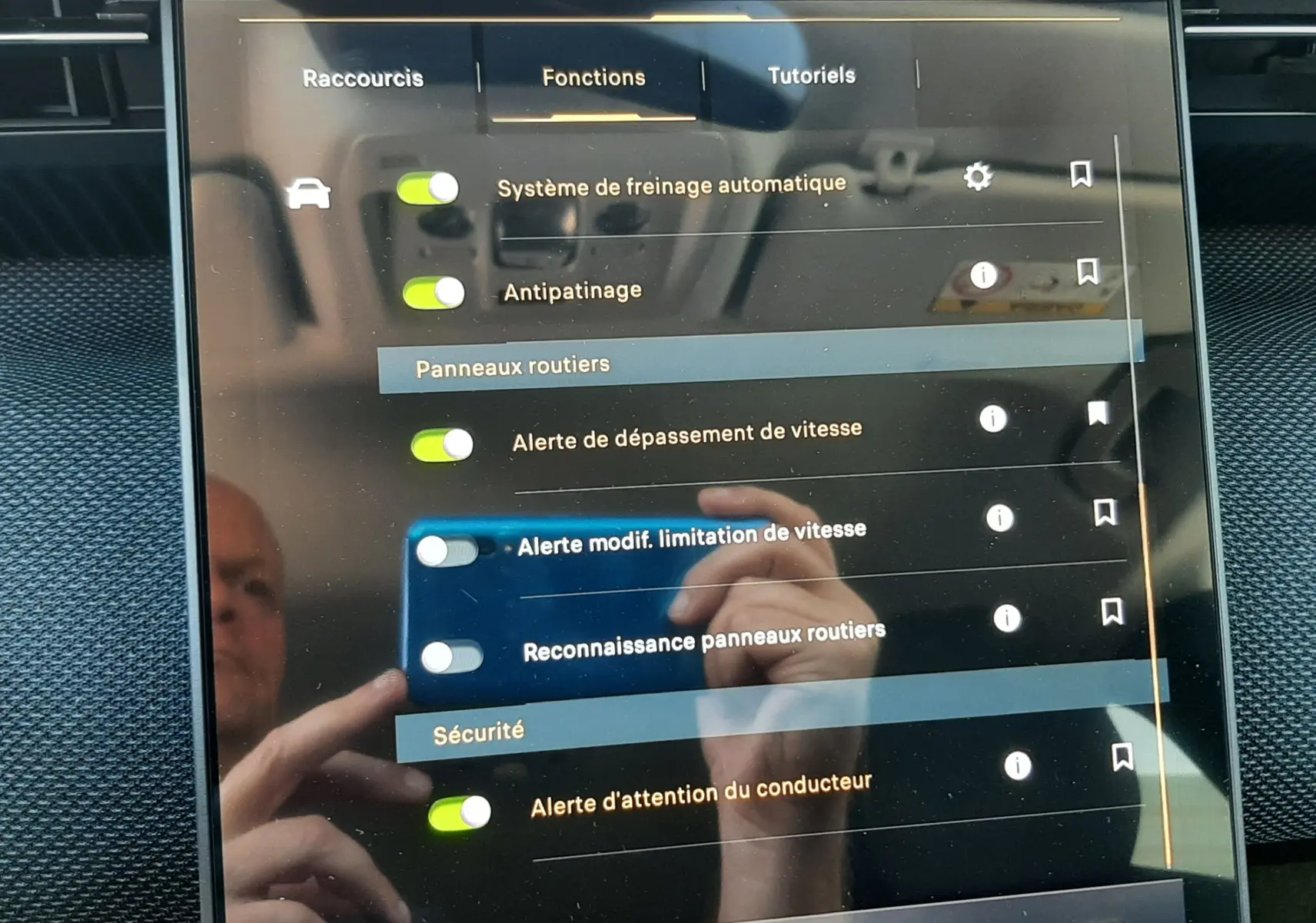 Écran tactile intérieur du Citroën C5 Aircross 2026 affichant les réglages d’aides à la conduite, avec reflet de la main.