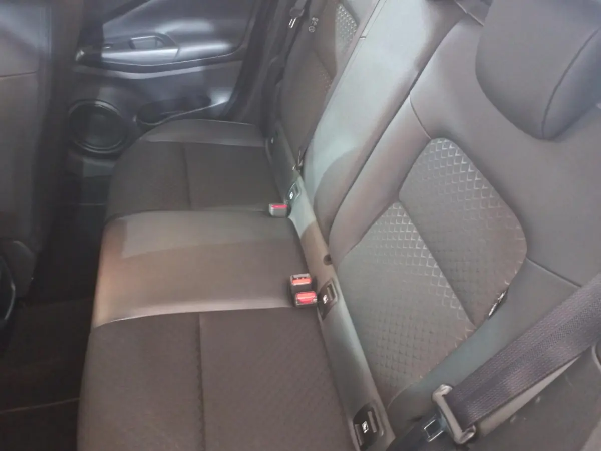 Vue intérieure du siège arrière droit du Nissan Juke Hybrid 143 Business+ 2023, tissu gris foncé avec ceinture de sécurité.
