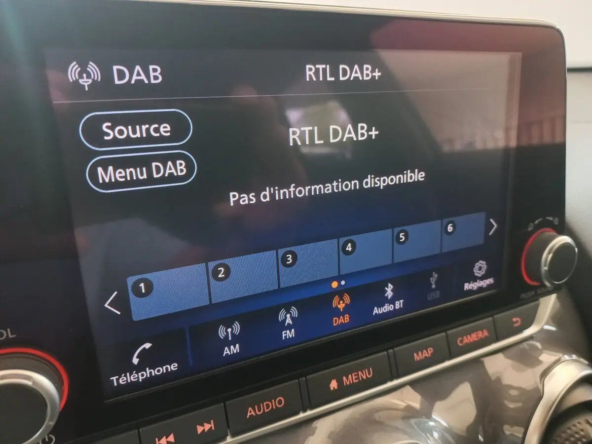 Écran tactile central du Nissan Juke Hybrid 143 Business+ 2023, affichant la radio DAB, vue rapprochée intérieure.