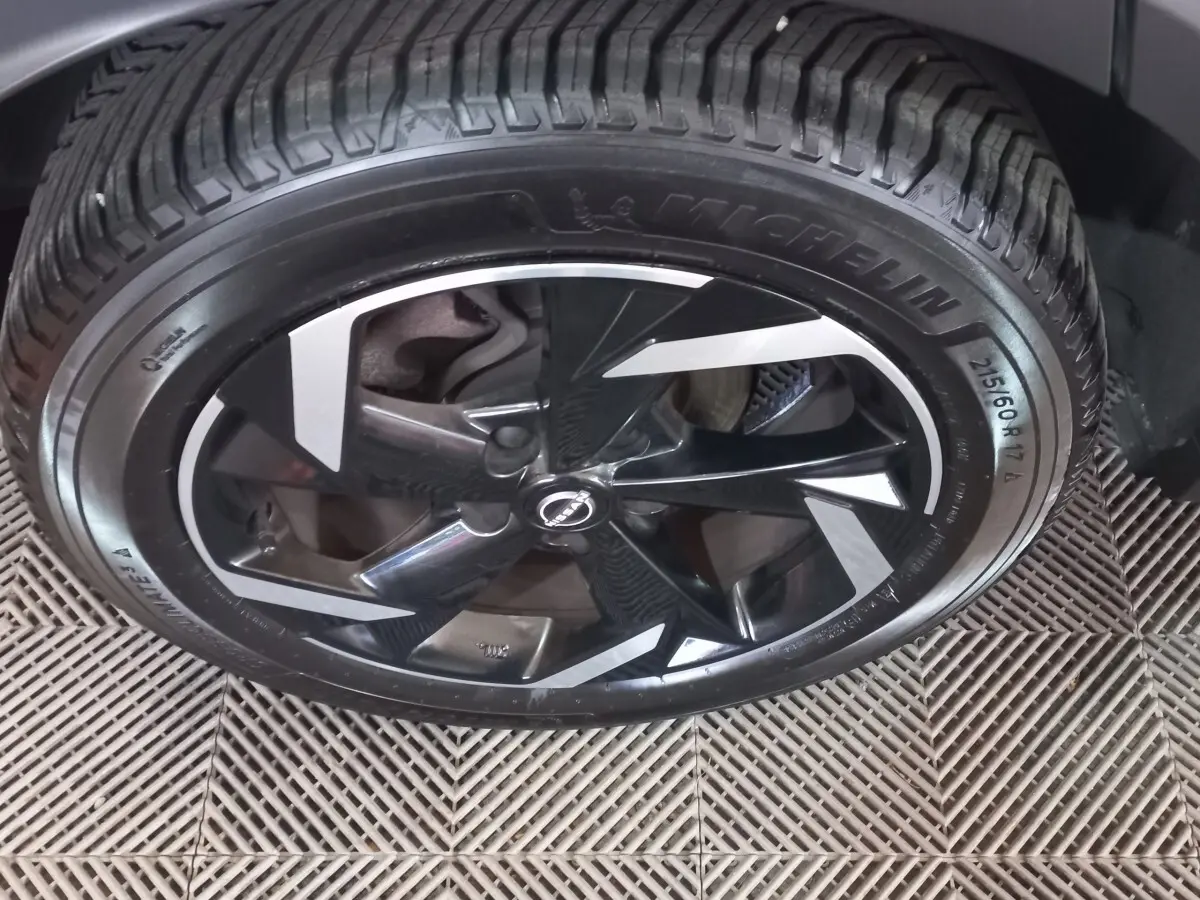 Gros plan sur la jante noire et argentée du Nissan Juke Hybrid 143 Business+ 2023 avec pneu Michelin.