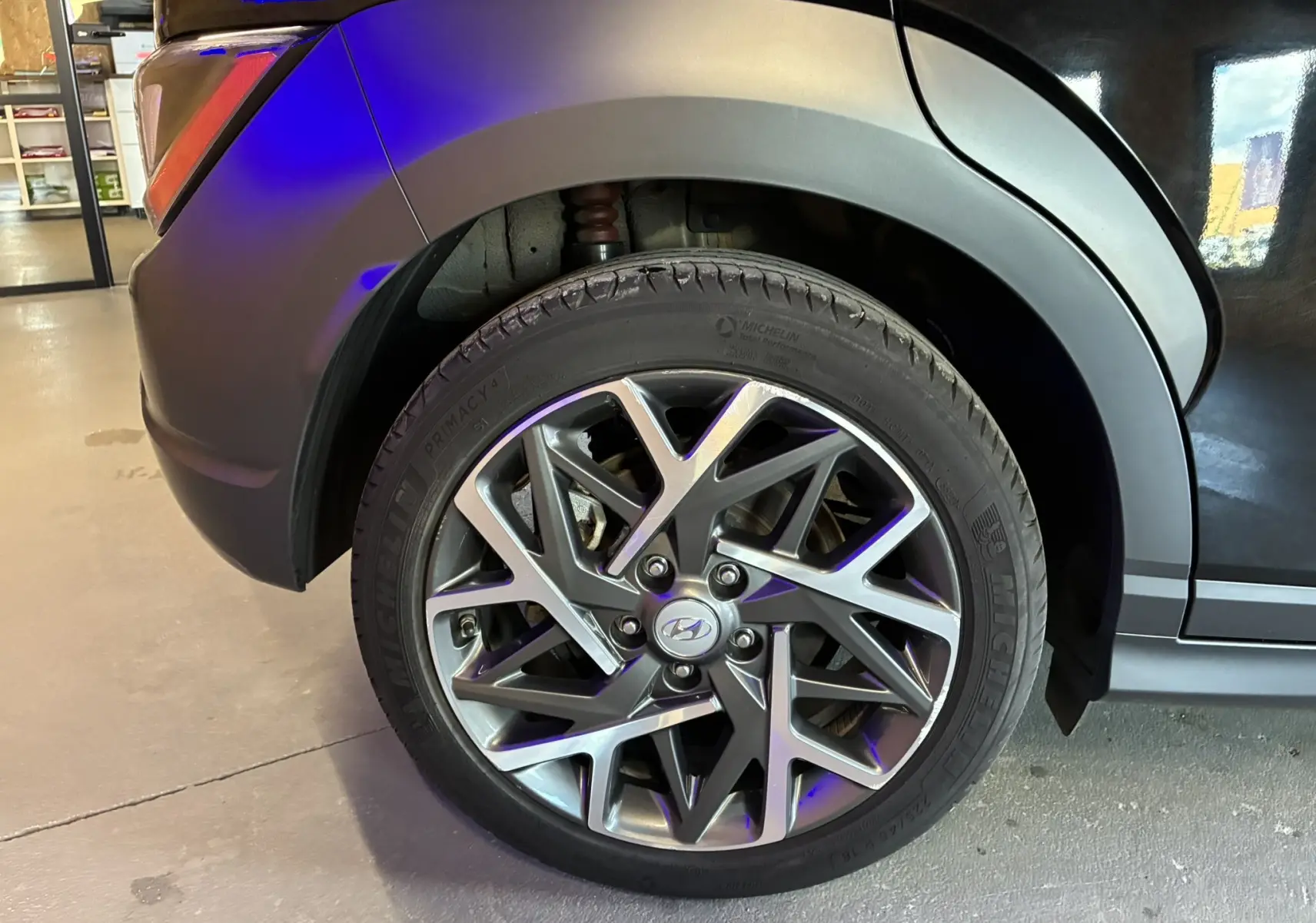 Gros plan sur la roue avant gauche du Hyundai Kona noir 2023, mettant en valeur la jante alliage au design moderne.