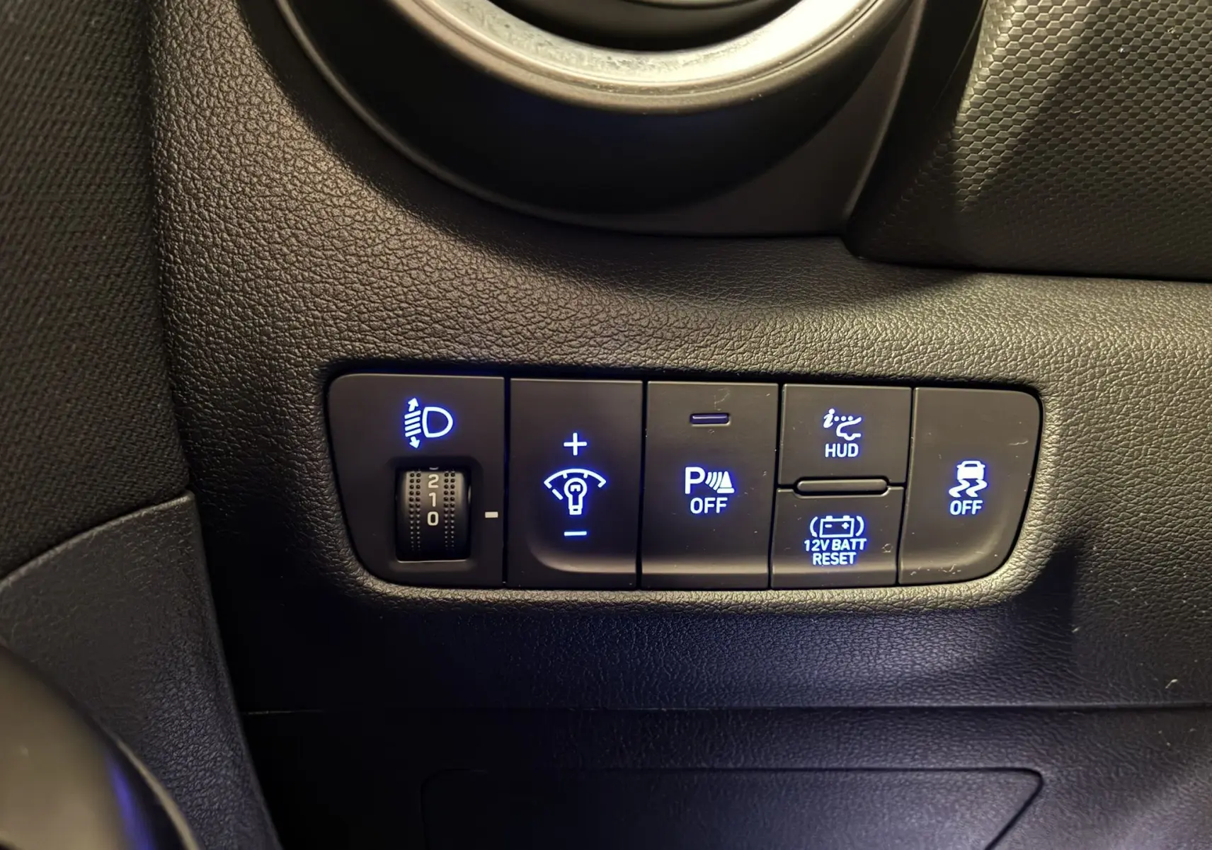Gros plan sur les commandes lumineuses et aides à la conduite du tableau de bord noir du Hyundai Kona 1.6 GDI 140 Creative 2023.