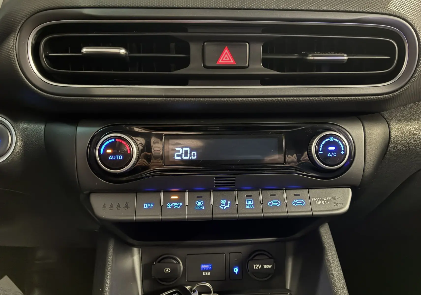 Tableau de bord noir du Hyundai Kona 2023, zoom sur commandes climatisation digitale et ventilation centrale.