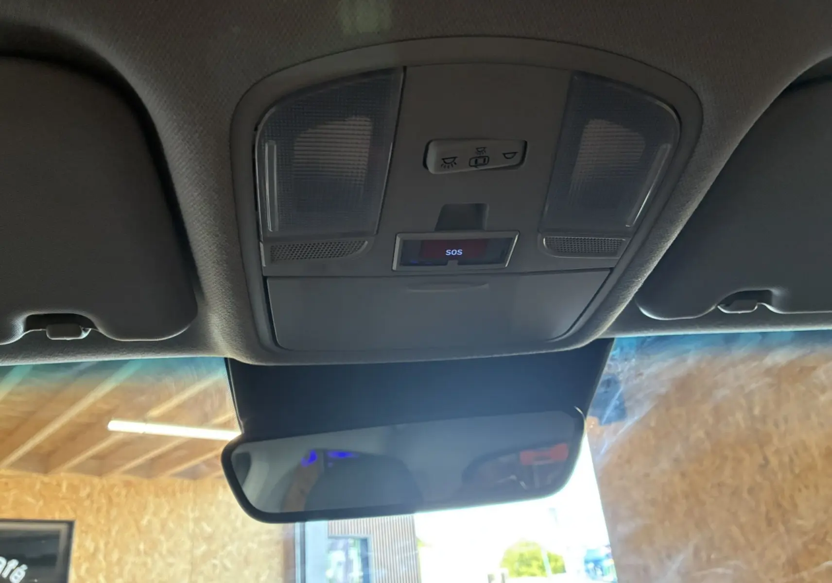Vue intérieure du plafonnier avec commandes d'éclairage et bouton SOS au-dessus du rétroviseur d'une Hyundai Kona noire 2023.