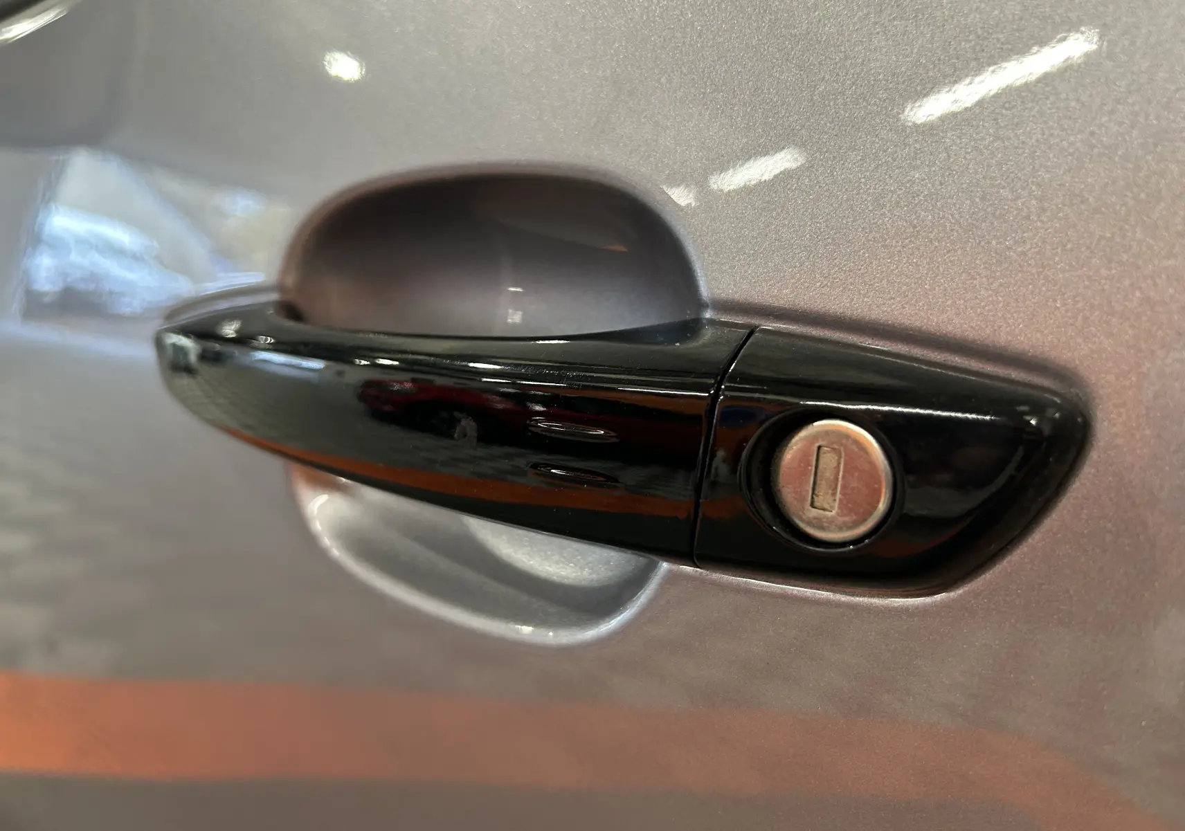 Poignée de porte noire avec serrure sur la portière gris artense d'un Citroën Berlingo Multispace 2025.