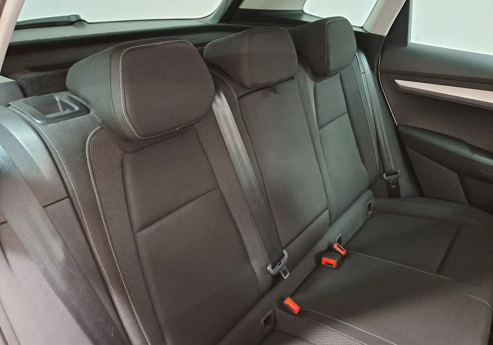 Vue intérieure des sièges arrière noirs du Skoda Karoq 2025, soulignant les appuie-têtes et ceintures de sécurité.