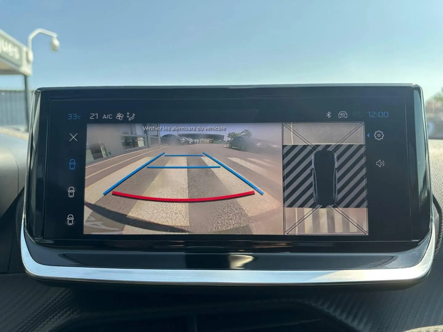 Écran tactile intérieur de la Peugeot 208 2025 montrant la caméra de recul avec guidage et vue 360° du véhicule.