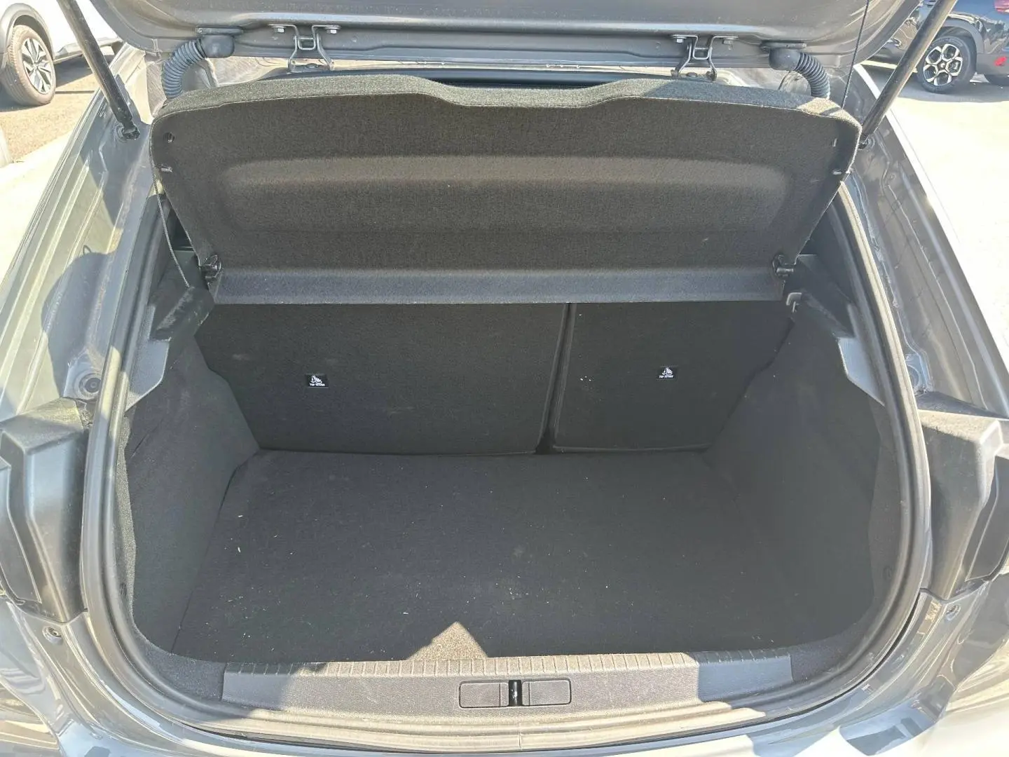 Coffre ouvert d’une Peugeot 208 gris Selenium 2025, vue plongeante sur l’espace de chargement vide.