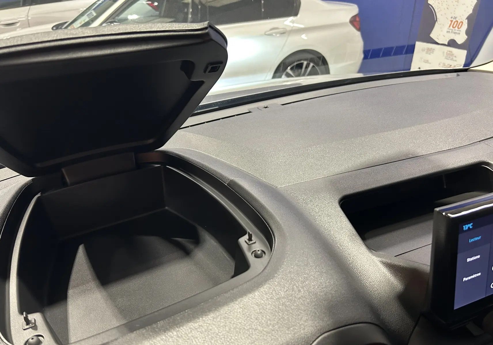 Coffre de rangement ouvert sur le tableau de bord du Citroën Berlingo Multispace gris Artense, vue intérieure avant droite.