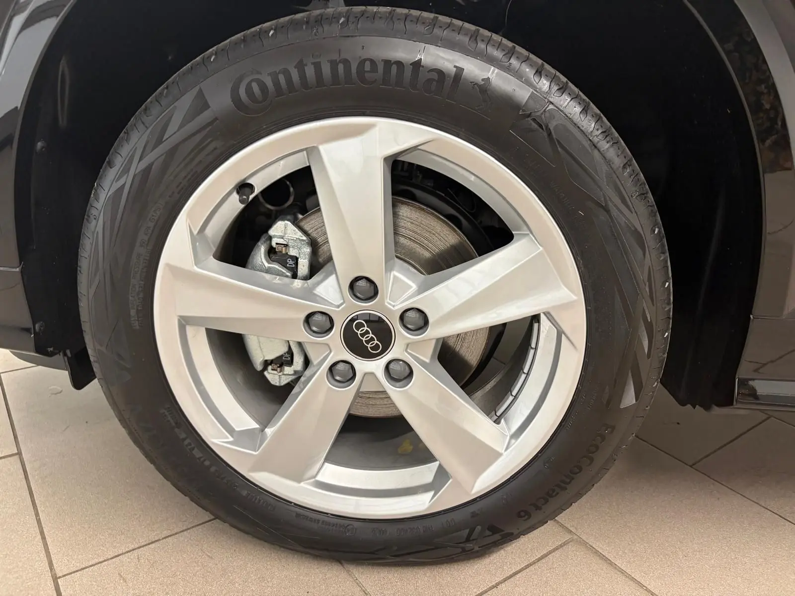 Gros plan sur la roue avant droite d’un Audi Q2 Noir Mythic avec jante alliage et pneu Continental.