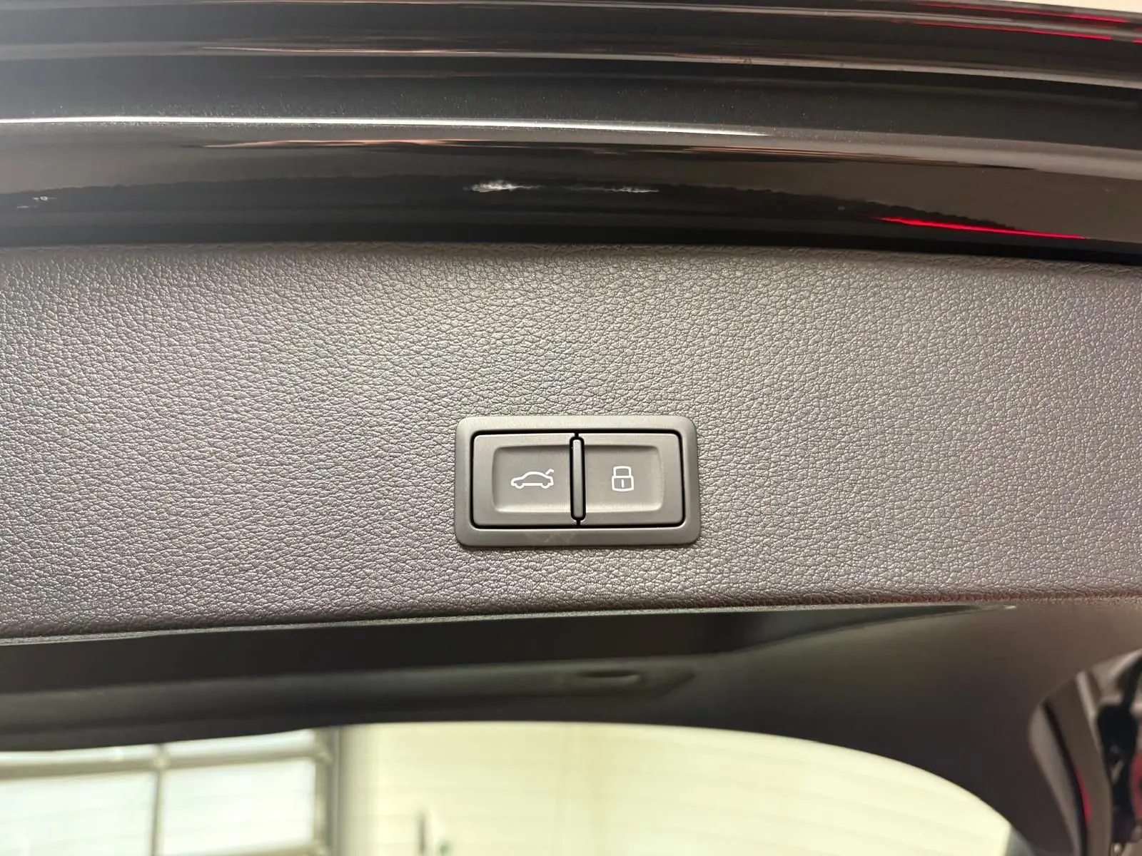 Boutons de commande du hayon électrique sur la partie intérieure du coffre d'un Audi Q2 Noir Mythic 2026.