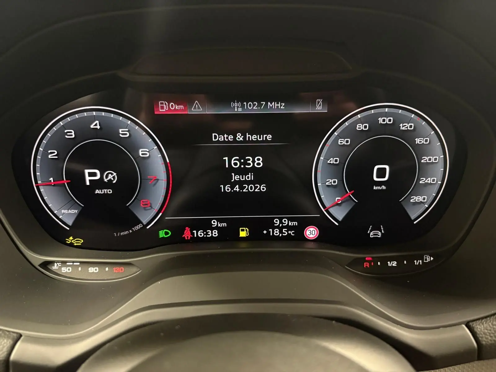 Vue rapprochée du tableau de bord numérique de l'Audi Q2 35 TFSI 2026 affichant la date, l'heure et les compteurs en mode automatique.