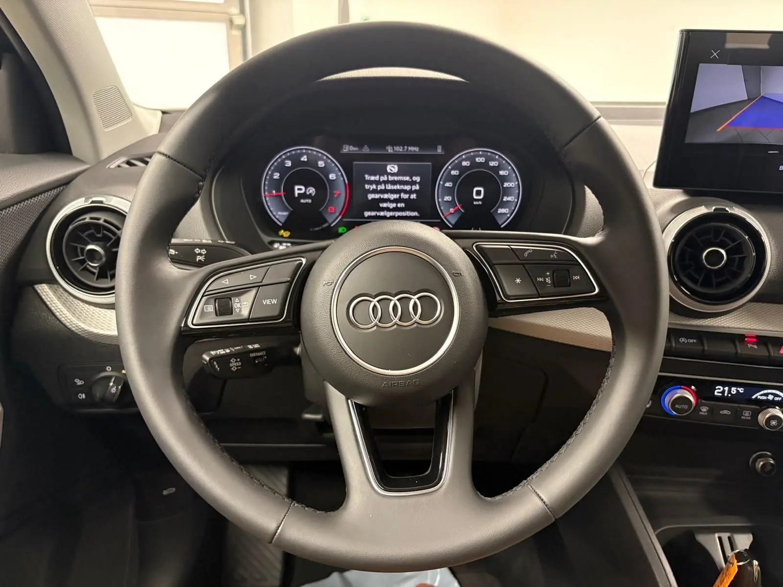 Vue rapprochée du volant multifonction de l’Audi Q2 35 TFSI S Line 2026 avec tableau de bord numérique.