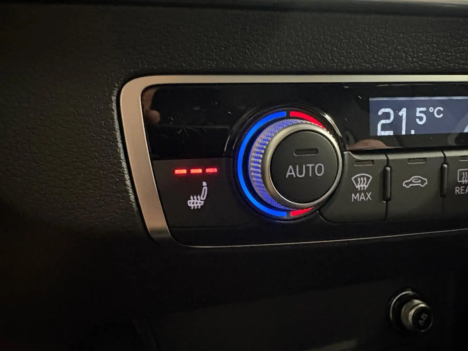 Bouton de réglage automatique de la climatisation avec indication de siège avant chauffant dans un Audi Q2 noir Mythic.