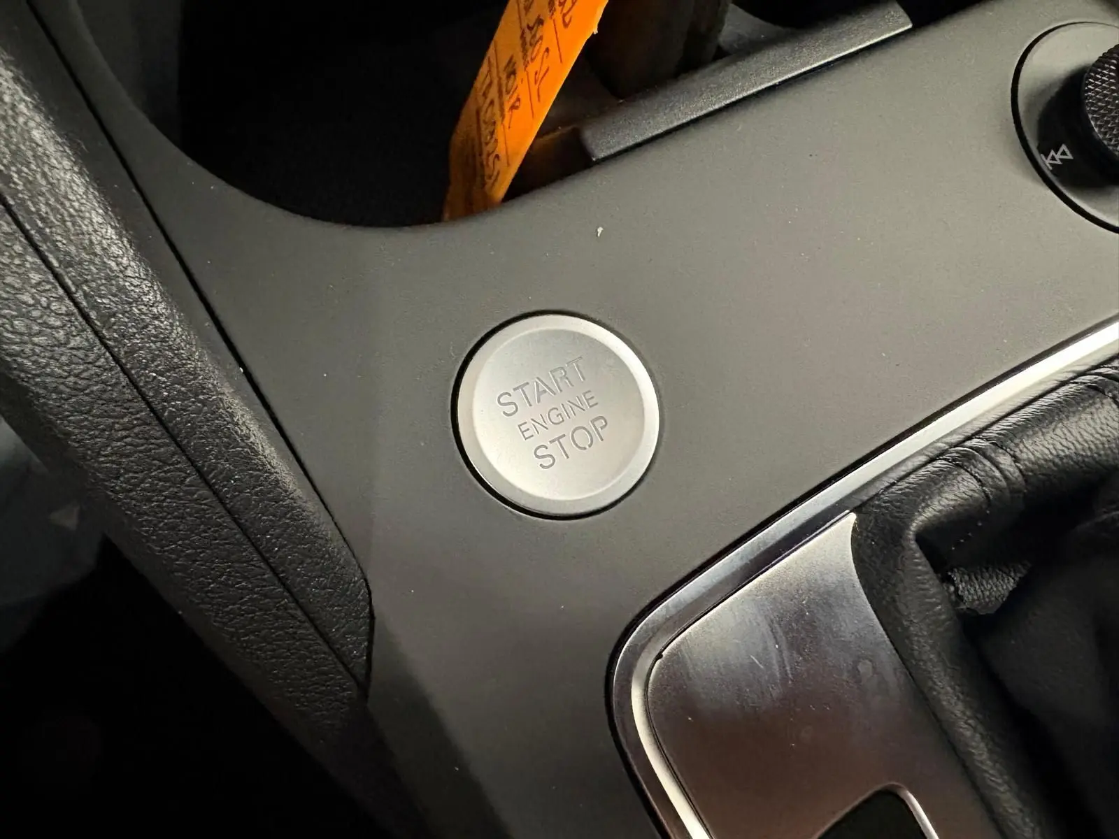 Gros plan sur le bouton start/stop moteur dans l’habitacle d’un Audi Q2 Noir Mythic, version S Line 2026.