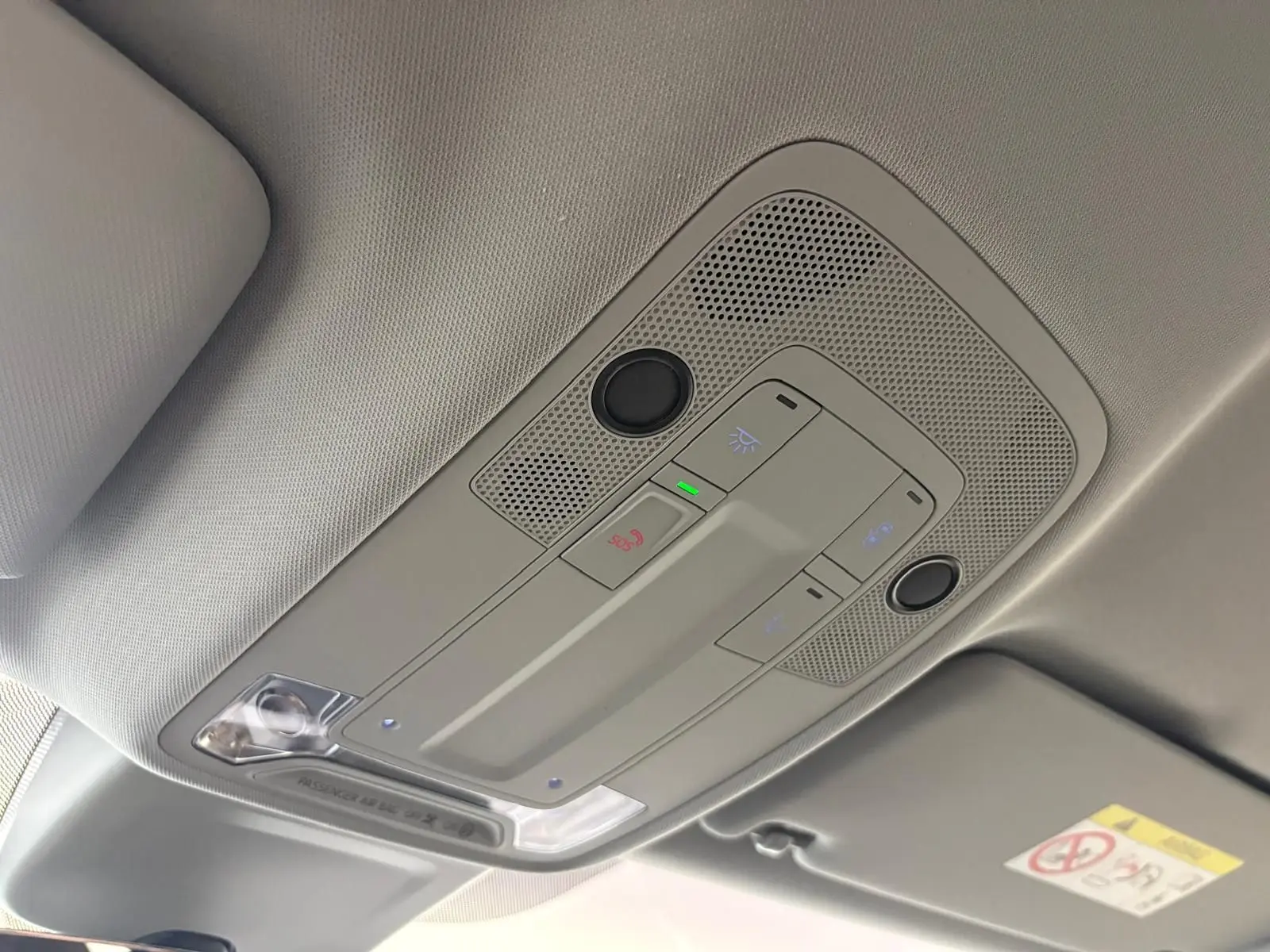 Plafonnier intérieur gris clair avec commandes d’éclairage et bouton SOS dans un Audi Q2 Noir Mythic 2026.