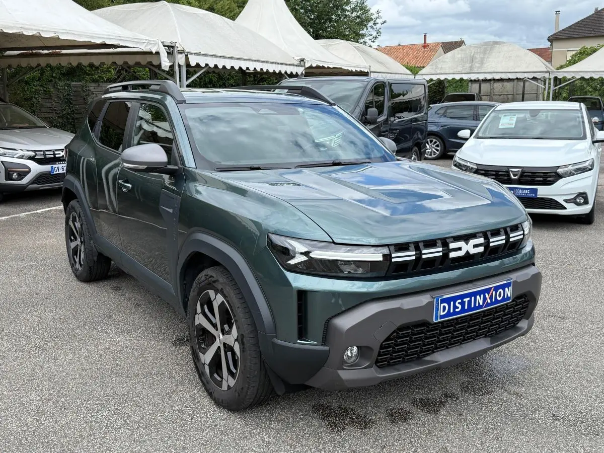 SUV Dacia Duster Hybrid 140 Journey vert cèdre en 3/4 avant avec calandre noire distinctive et jantes noires et argentées.