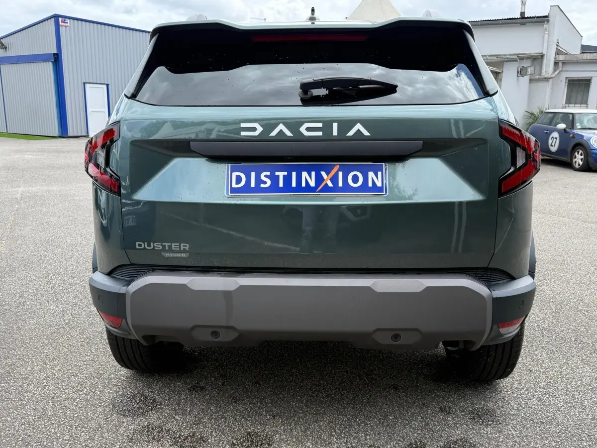 Vue arrière du Dacia Duster Hybrid 140 Journey vert cèdre avec logo DACIA et feux arrière LED distinctifs.