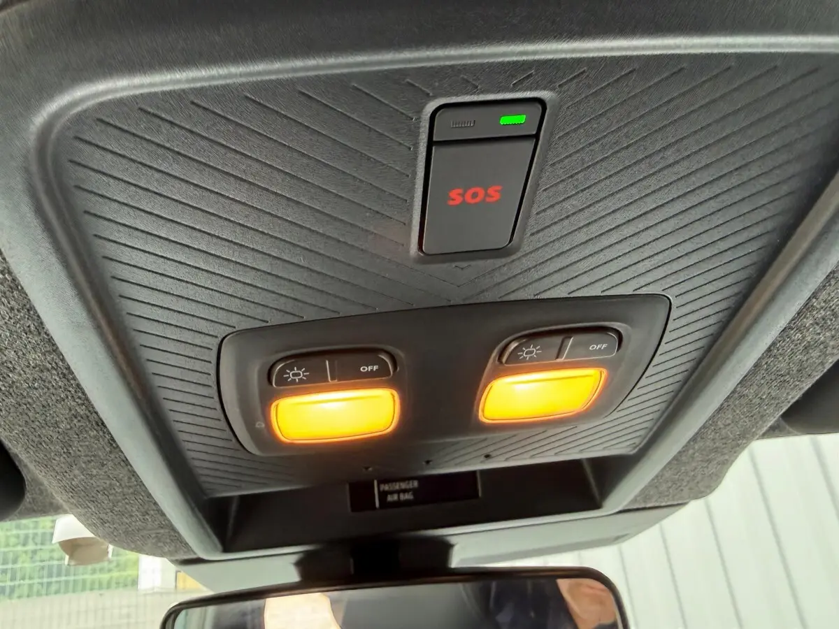 Vue intérieure du plafonnier avec éclairage orange et bouton SOS du Dacia Duster Hybrid 140 Journey 2025.