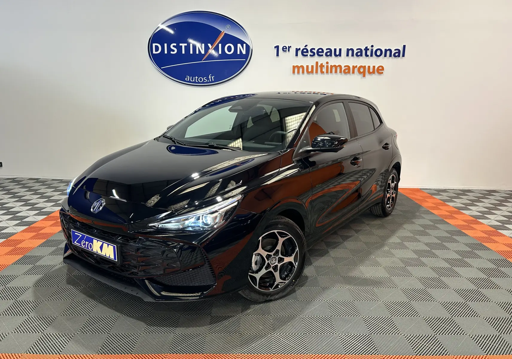 MG3 Hybrid+ 195 Luxury Pebble Black en 3/4 avant droit, avec jantes alliage et phares LED allumés, en showroom.