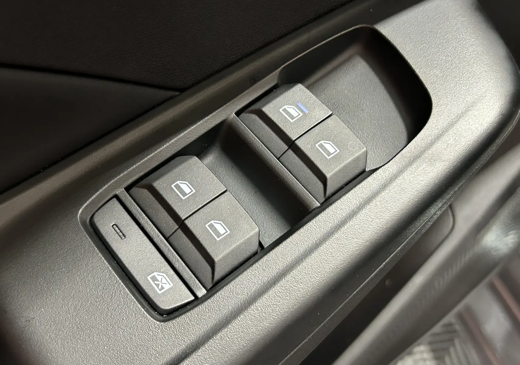 Gros plan sur les commandes des vitres électriques côté conducteur de la MG3 1.5 Hybrid+ Pebble Black, intérieur noir.