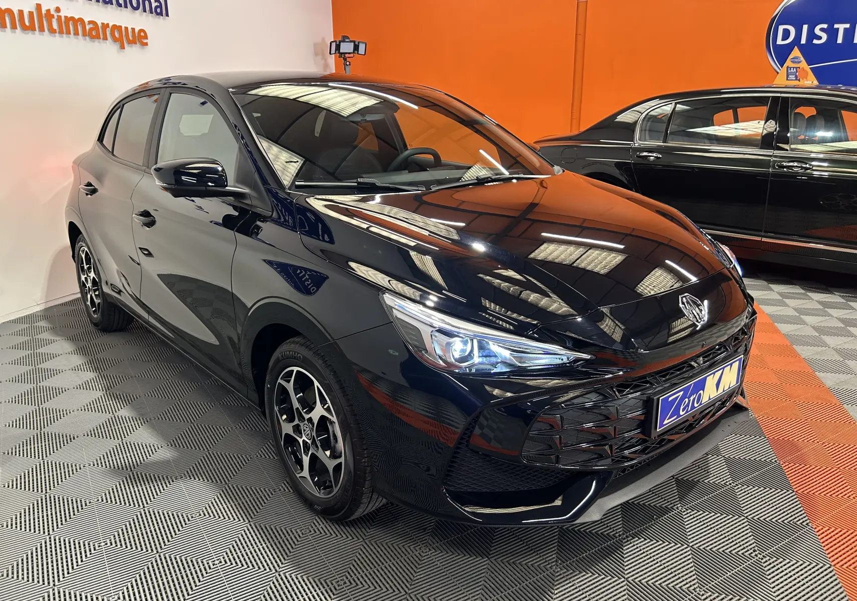 Vue 3/4 avant du MG3 Hybrid+ 195 Luxury Pebble Black, avec phares LED allumés et jantes distinctives en concession.