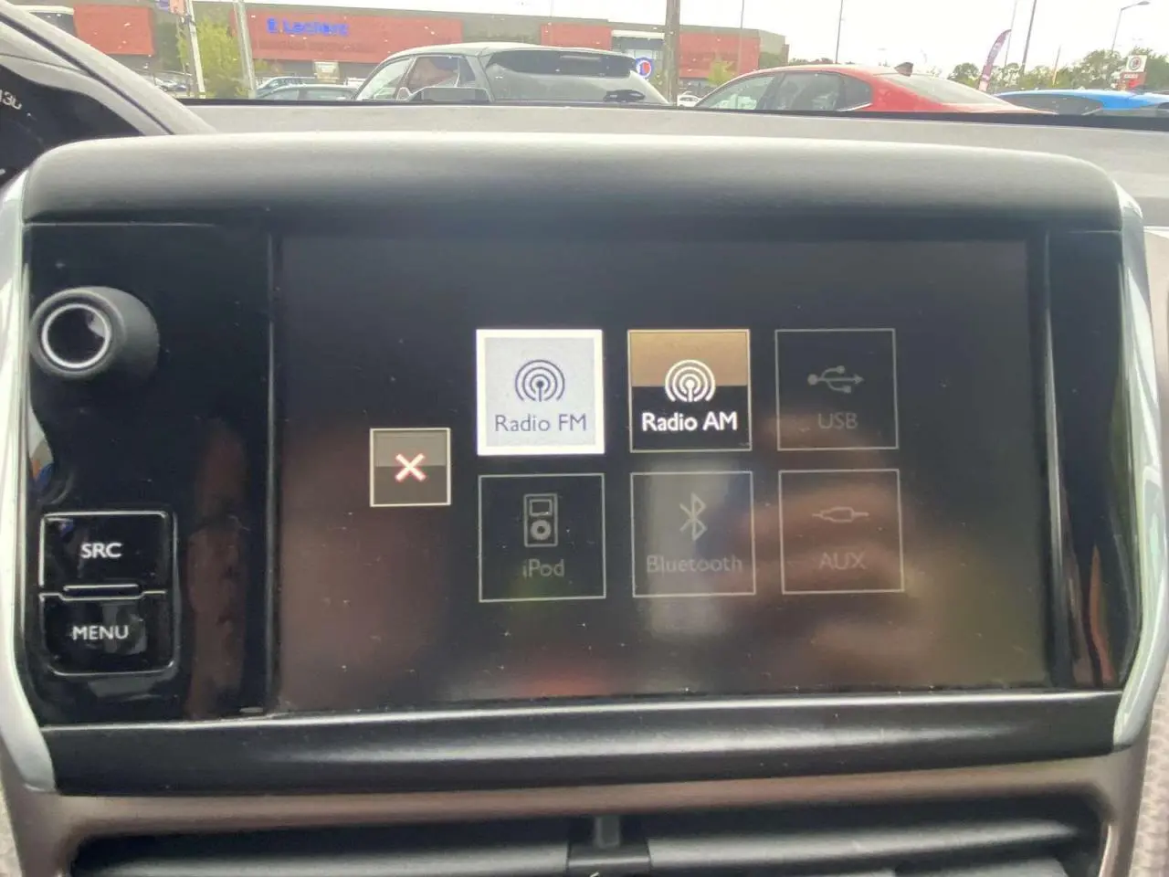 Vue intérieure du tableau de bord du Peugeot 2008 blanc de 2015, écran tactile affichant options Radio FM et AM.
