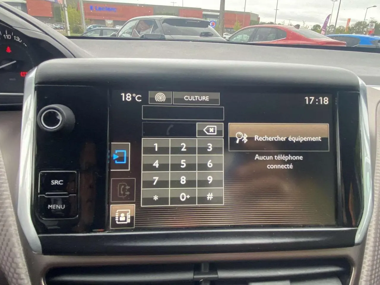 Vue intérieure du tableau de bord du Peugeot 2008 blanc 2015, avec écran tactile affichant le menu téléphone.