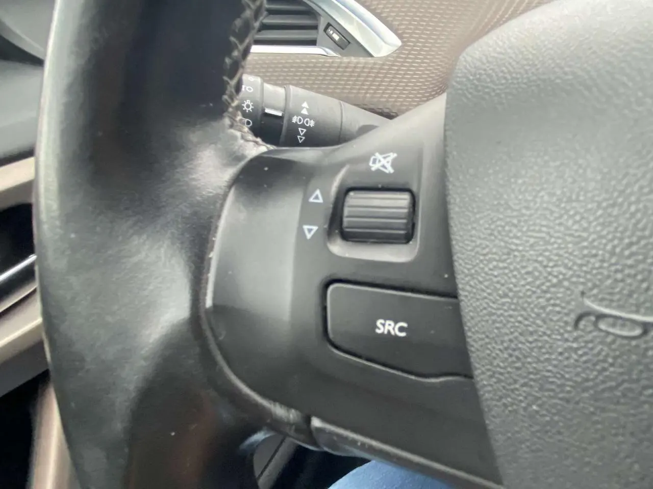 Gros plan sur les commandes au volant du Peugeot 2008 blanc 2015, version essence 1.2i PureTech Allure.