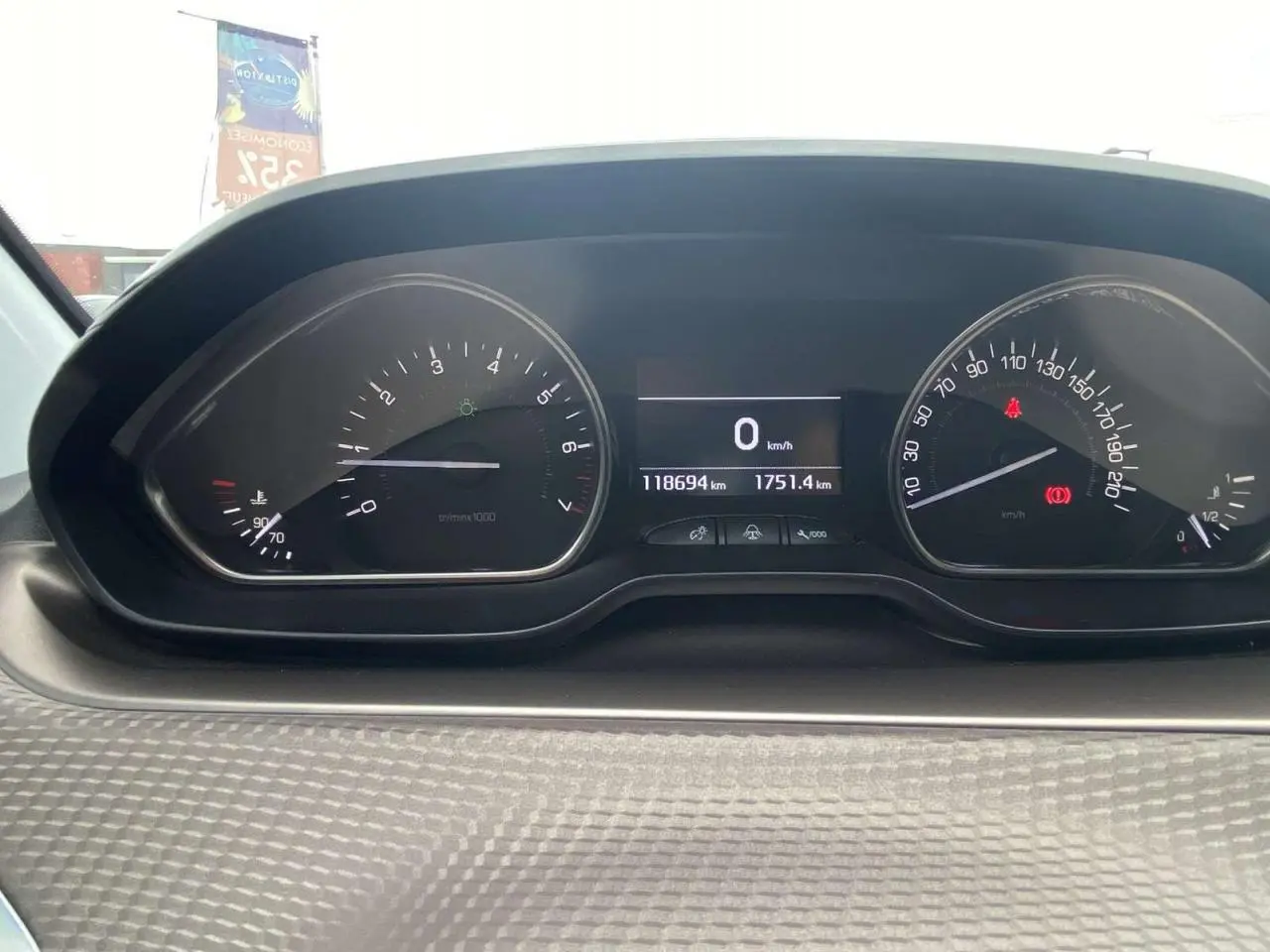 Tableau de bord du Peugeot 2008 blanc 2015, affichant compteur de vitesse et compte-tours avec 118694 km au compteur.