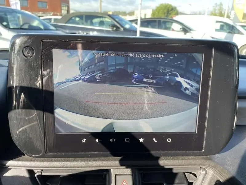 Vue arrière via caméra de recul d'une Suzuki Swift blanche 2025, version 1.2 Hybrid 83 CV Pack Auto, en stationnement.