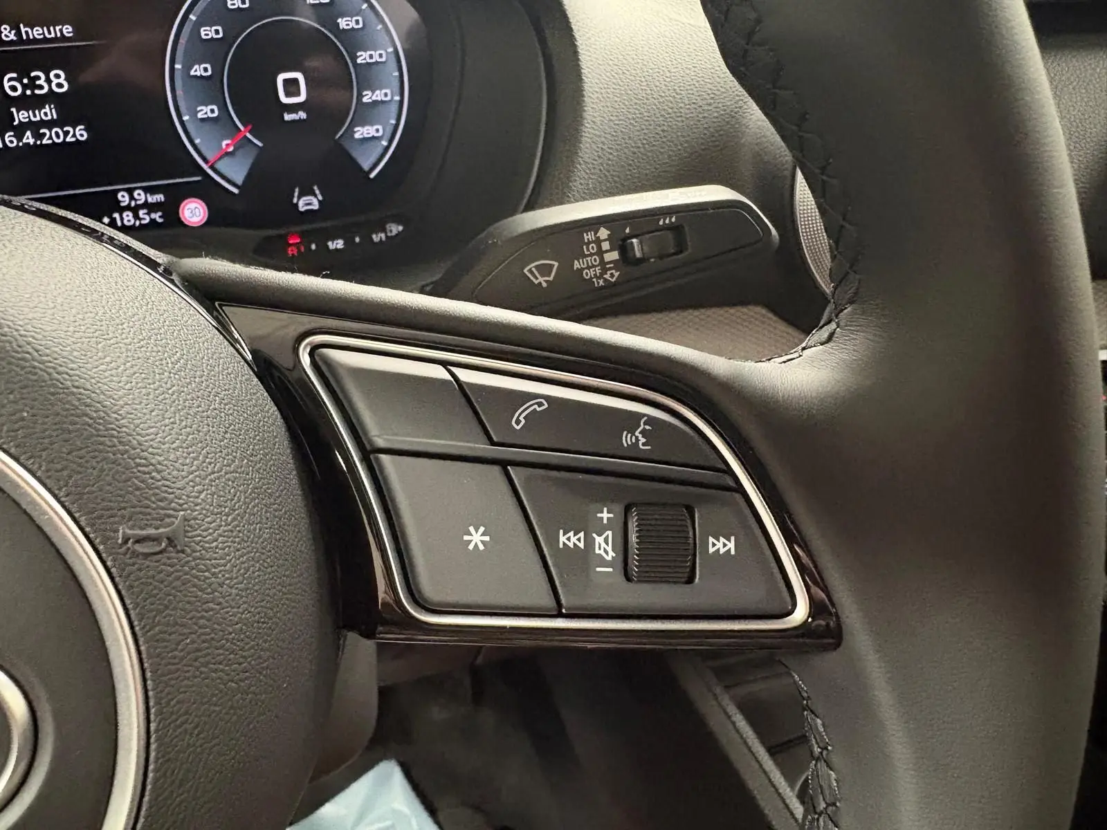 Gros plan sur les commandes au volant d’un Audi Q2 35 TFSI S line 2026 avec tableau de bord numérique.