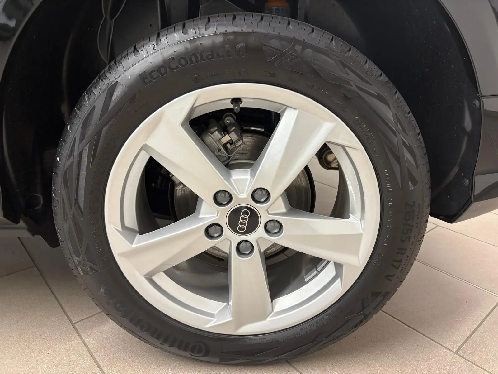 Gros plan sur la roue avant droite de l'Audi Q2 35 TFSI S Line 2026 en Noir Mythic avec jante argentée cinq branches.