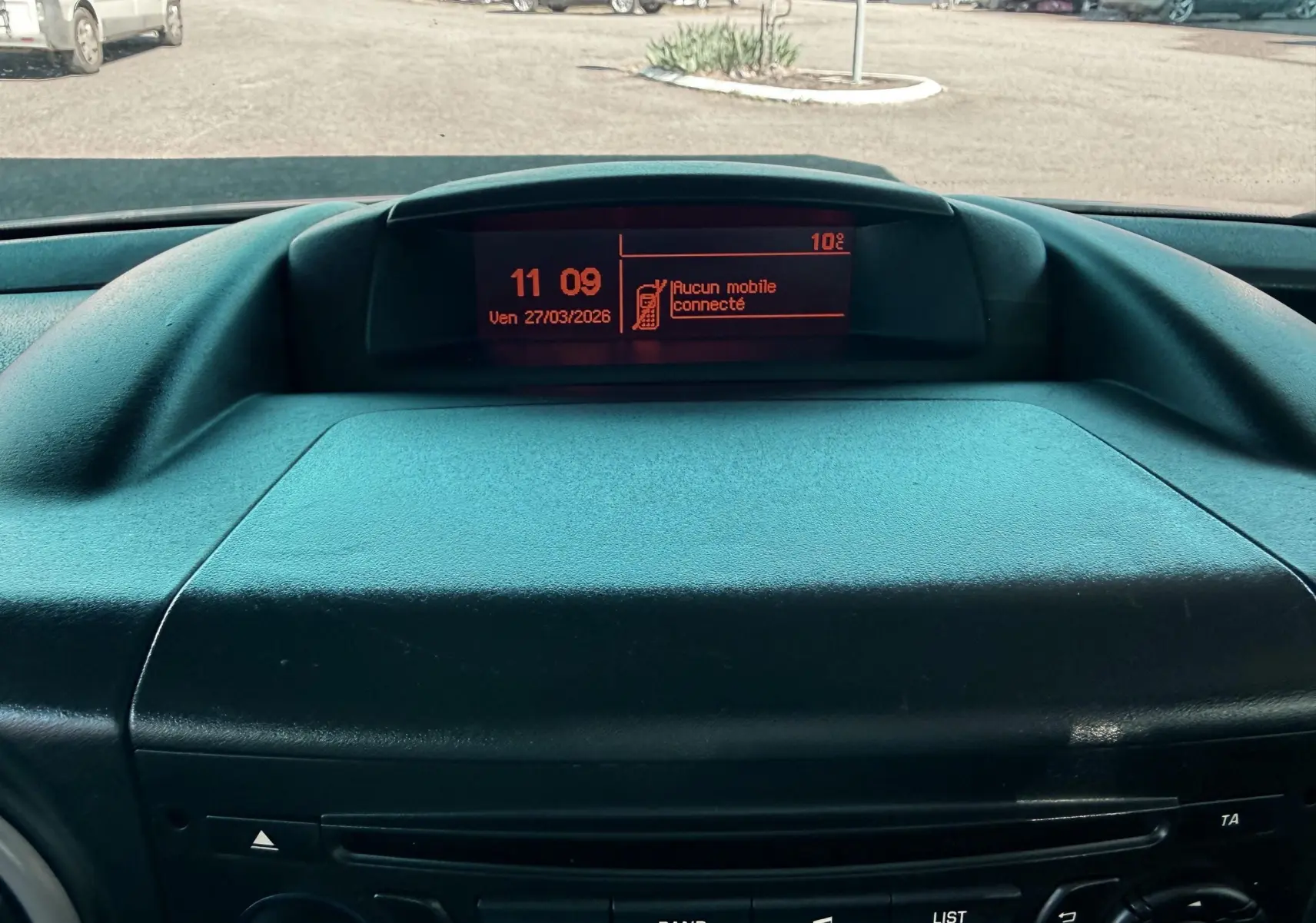 Vue rapprochée du tableau de bord noir du Citroën Berlingo 2017 avec écran central affichant l'heure et la température.